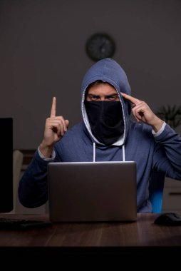 Erkek bilgisayar korsanı, güvenlik duvarını geç saatlerde hackliyor.