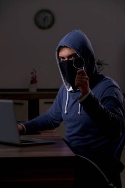 Erkek bilgisayar korsanı, güvenlik duvarını geç saatlerde hackliyor.