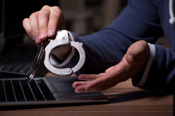 Male hacker hacking security firewall late in office