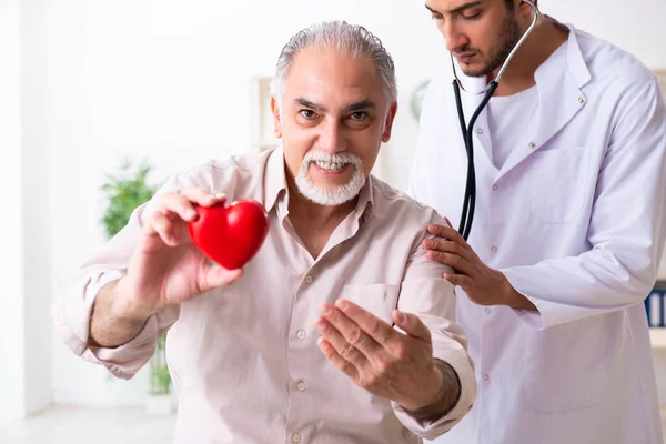 Starý muž návštěva mladý lékař kardiolog — Stock fotografie