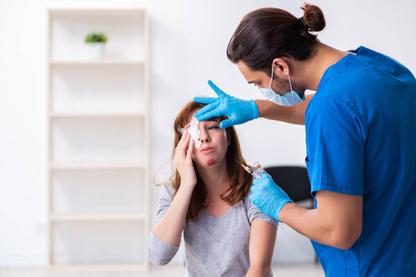 Young head injured woman visiting young male doctor