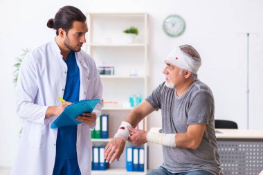 İlk yardım konseptinde genç erkek doktor ve yaşlı hasta.