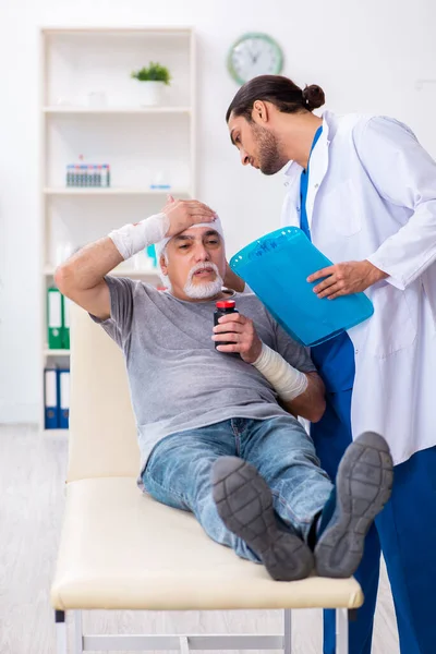 Giovane medico maschio e paziente anziano nel concetto di pronto soccorso — Foto Stock