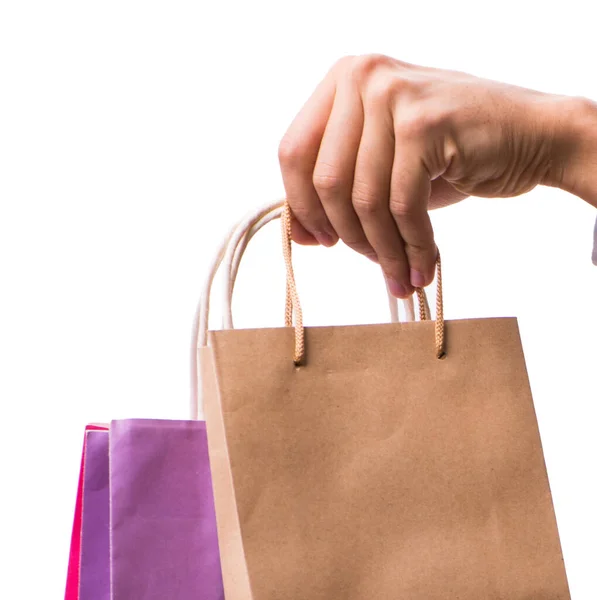 Mão segurando sacos de compras com compras de Natal na parte traseira branca — Fotografia de Stock