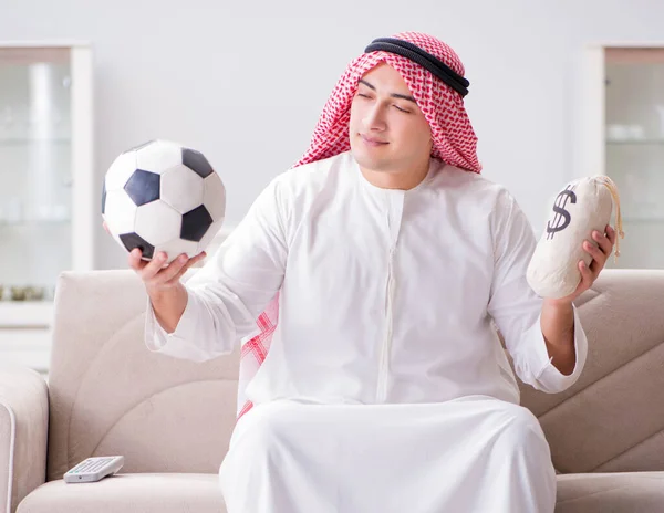 Hombre árabe joven viendo fútbol sentado en el sofá — Foto de Stock