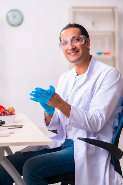 Joven experto en nutrición masculina probando productos alimenticios en laboratorio —  Fotos de Stock