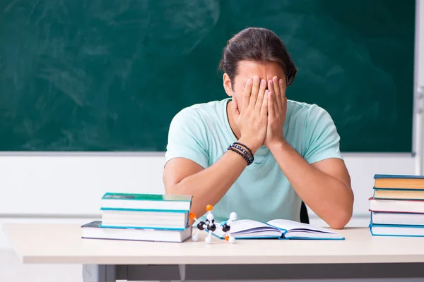 Jeune étudiant assis dans la salle de classe — Photo