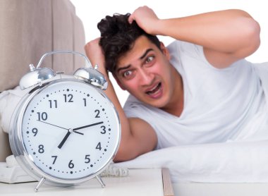 Yatakta uykusuzluk çeken bir adam.