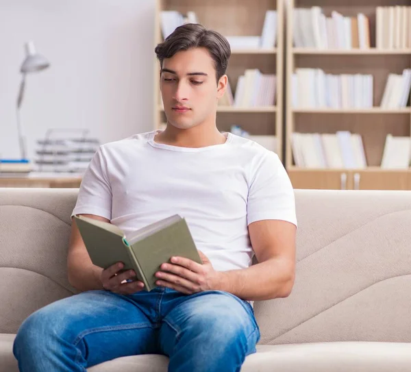 Homme lisant le livre assis dans le canapé — Photo