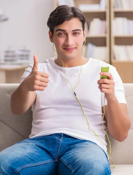 Homem ouvindo música sentado no sofá — Fotografia de Stock