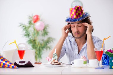 Genç adam doğum gününü evde kutluyor.