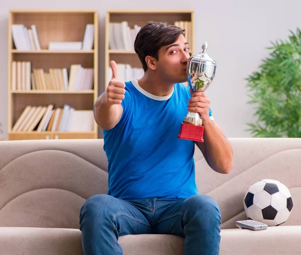 Homem assistindo futebol em casa sentado no sofá — Fotografia de Stock