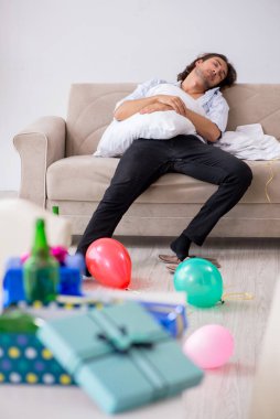 Genç adam doğum gününü evde kutluyor.