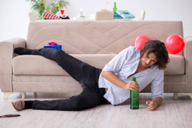 Genç adam doğum gününü evde kutluyor.