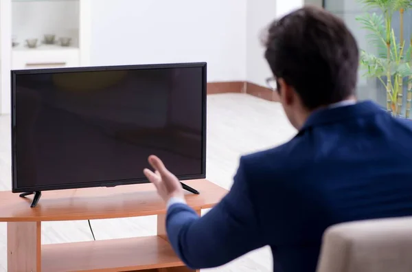 Uomo d'affari che guarda la tv in ufficio — Foto Stock