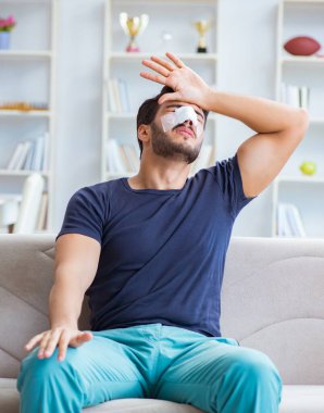 Genç adam estetik cerrahi burnundan sonra evde iyileşiyor.