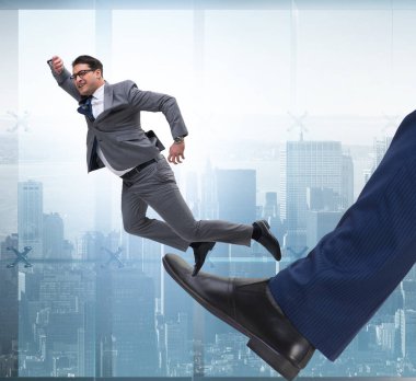 Kötü kızgın patron, çalışanı iş konseptinde tekmeliyor.