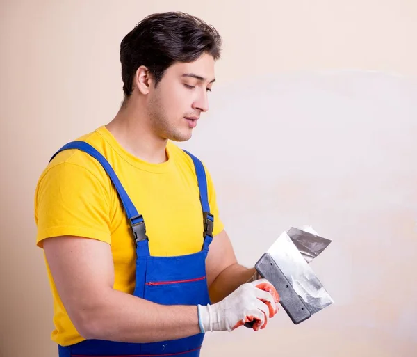 Empleado joven contratista aplicando yeso en la pared — Foto de Stock