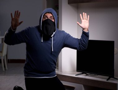 Hırsız, apartmandan televizyon çalıyor.