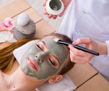 Yüz maskeli, spa sağlık konsepti olan genç bir kadın.
