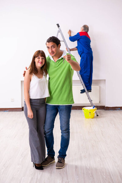 Young couple and old contractor in home renovation concept