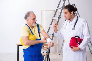 İlk yardım konseptinde genç erkek doktor ve yaşlı müteahhit.