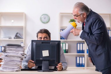 Eski patron ve genç erkek çalışan ofiste.