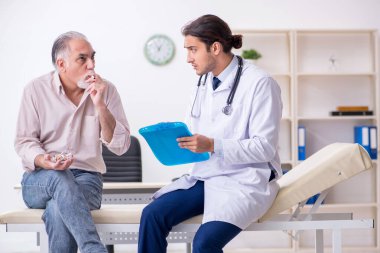 Sigara karşıtı genç erkek doktor ve yaşlı hasta