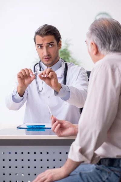 Ung manlig läkare och gammal patient i antirökningskoncept — Stockfoto