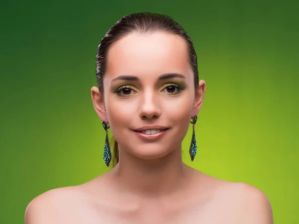 Молодая женщина в концепции красоты на зеленом фоне — стоковое фото