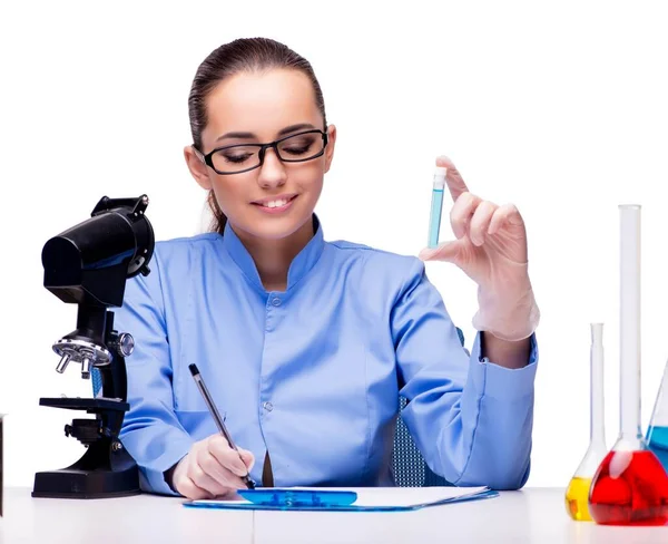 Químico de laboratório trabalhando com microscópio e tubos — Fotografia de Stock