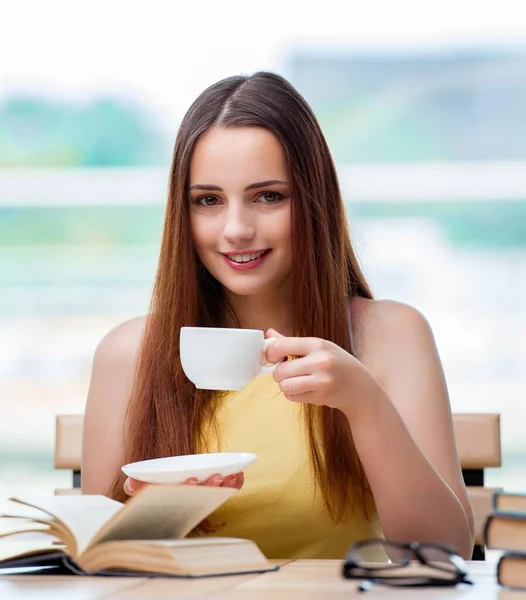 Junge Studentin bereitet sich auf Prüfungen vor und trinkt Tee — Stockfoto