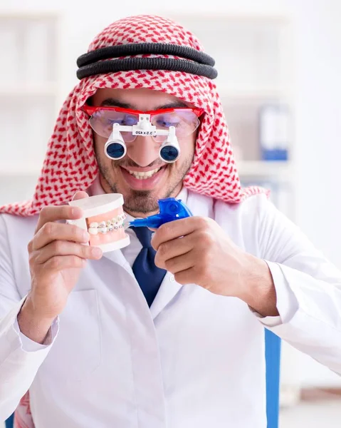 Odontólogo árabe trabajando en un nuevo implante dental — Foto de Stock