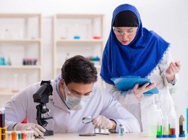 Laboratuvarda çalışan iki kimyager.