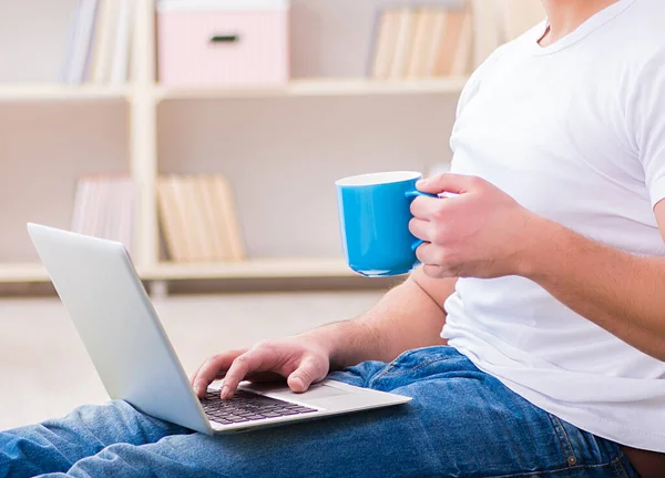 Mann arbeitet zu Hause am Laptop auf Teppichboden — Stockfoto