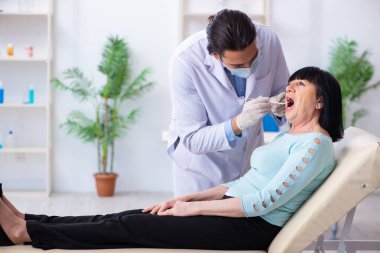 Yaşlı kadın genç dişçiyi ziyaret ediyor.