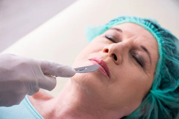 Oude vrouw bezoekt mannelijke arts voor plastische chirurgie — Stockfoto