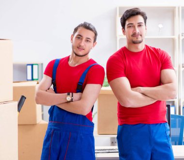 İki müteahhit personel kişisel eşyalarını taşıyor.