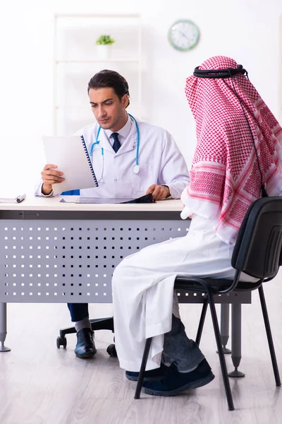 Old male arab visiting young male doctor — Stock Fotó