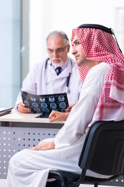 Young male arab visiting experienced male doctor — Stock fotografie