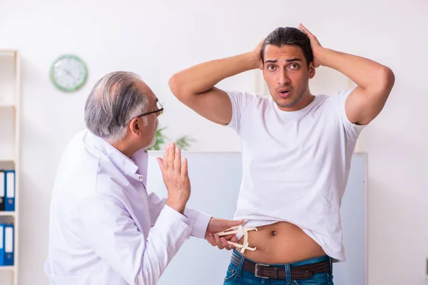 Médico dietista dando consejos a pacientes con sobrepeso de grasa — Foto de Stock