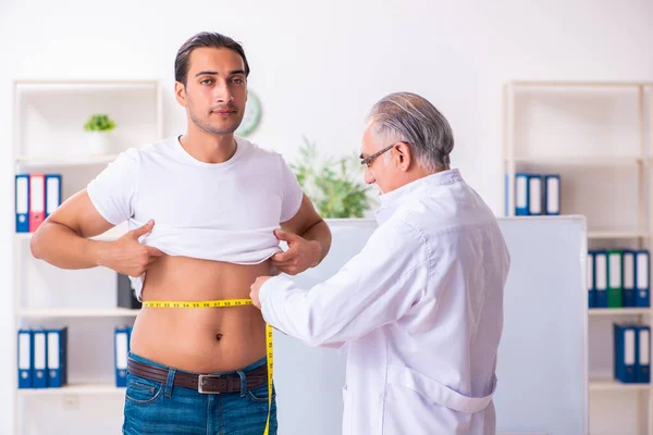 Médico dietista dando consejos a pacientes con sobrepeso de grasa — Foto de Stock