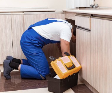 Mutfakta çalışan genç tamirci.