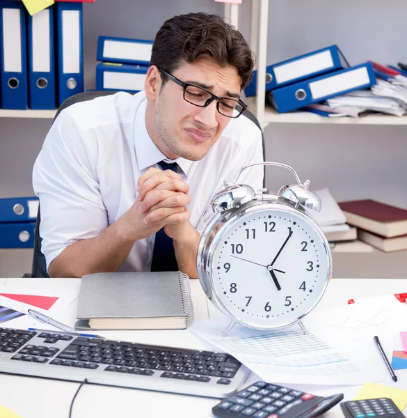 Homme d'affaires travaillant dans le bureau avec des piles de livres et de papiers — Photo