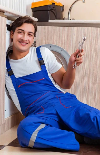 Reparateur repareert wasmachine in de keuken — Stockfoto