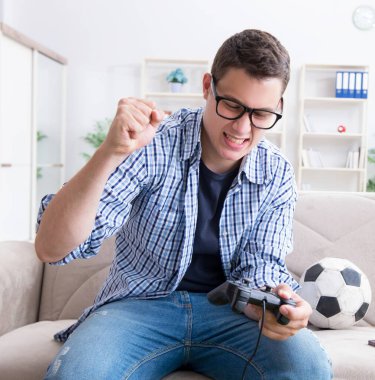 Genç adam evde bilgisayar oyunu oynuyor.