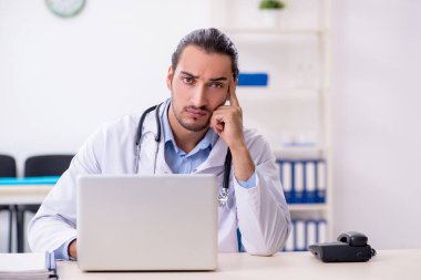 Klinikte çalışan yakışıklı genç erkek doktor.