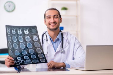 Klinikte çalışan yakışıklı genç erkek doktor.