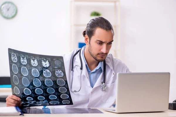 Jonge knappe mannelijke arts werkzaam in de kliniek — Stockfoto