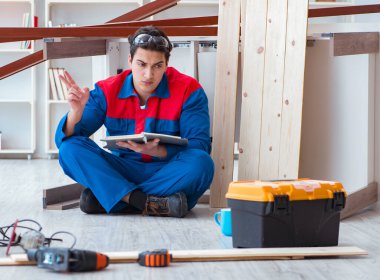 İnşaatta defter planlama yapan genç bir marangoz.